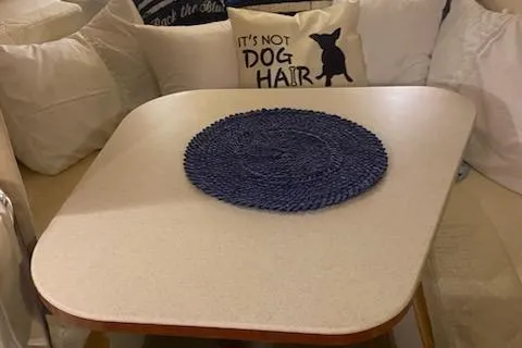 Slide: The Image of Interior of 2004 Sea Ray 280 Sundancer with table, pillows, and decorative mat. - 21