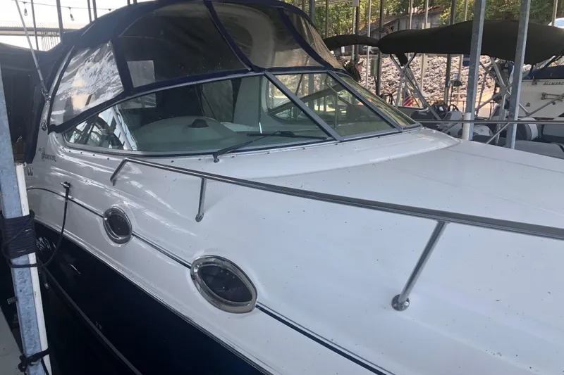 Slide: The Image of 2004 Sea Ray 280 Sundancer boat docked in a marina, featuring sleek design and windows. - 3