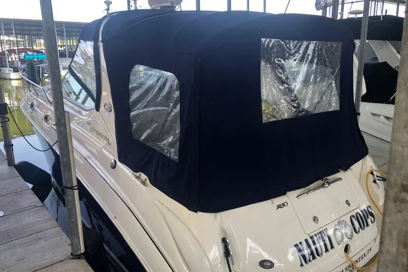 Slide: The Image of 2004 Sea Ray 280 Sundancer boat docked with protective cover, rear view. - 7