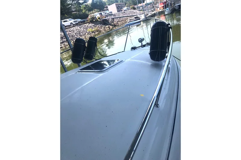 Slide: The Image of 2004 Sea Ray 280 Sundancer boat docked, featuring sleek deck and railings. - 8