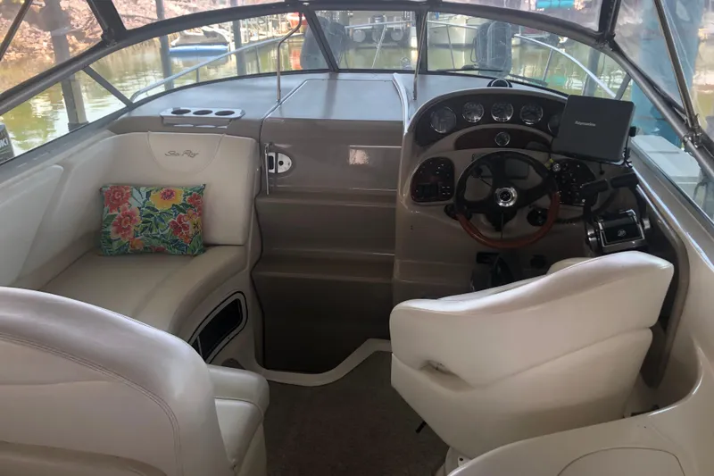 Slide: The Image of Interior of 2004 Sea Ray 280 Sundancer boat with steering wheel and floral cushion. - 9