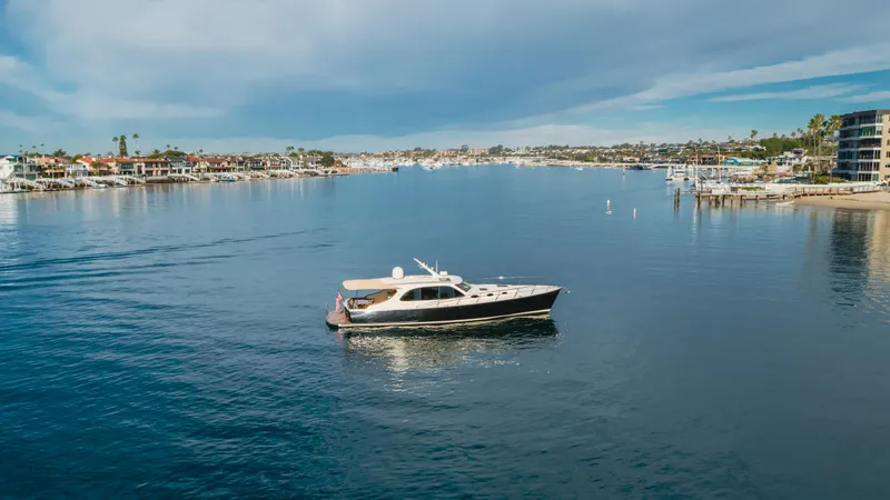 Slide: The Image of 2015 Palm Beach Motor Yachts 45 Sedan cruising in a serene coastal harbor. - 11