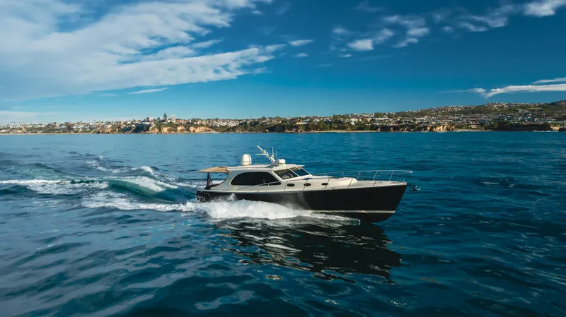 Slide: The Image of 2015 Palm Beach Motor Yachts 45 Sedan cruising on open water under a clear blue sky. - 13