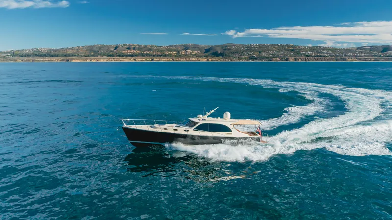 Slide: The Image of 2015 Palm Beach Motor Yachts 45 Sedan cruising on open water, scenic coastal backdrop. - 20