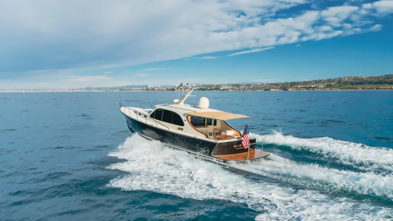 Slide: The Image of 2015 Palm Beach Motor Yachts 45 Sedan cruising on open water under a clear sky. - 23