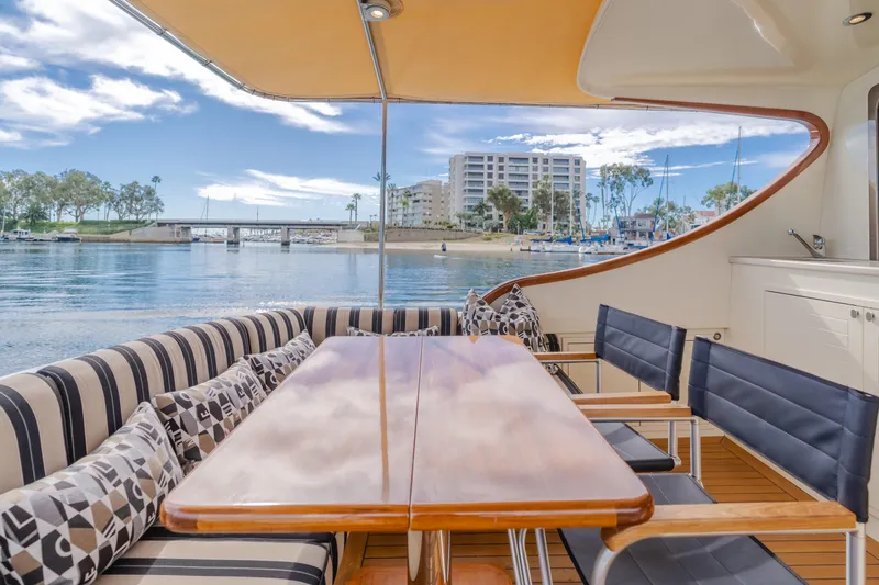 Slide: The Image of Luxurious 2015 Palm Beach Motor Yachts 45 Sedan with elegant outdoor seating and scenic waterfront view. - 25