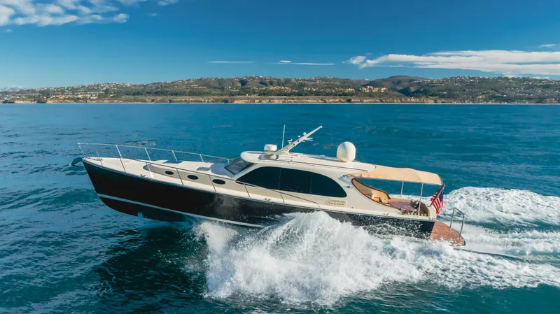 Slide: The Image of 2015 Palm Beach Motor Yachts 45 Sedan cruising on open water, scenic coastal backdrop. - 26