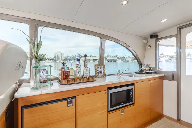 Slide: The Image of Interior of 2015 Palm Beach Motor Yachts 45 Sedan with kitchenette and scenic window view. - 27