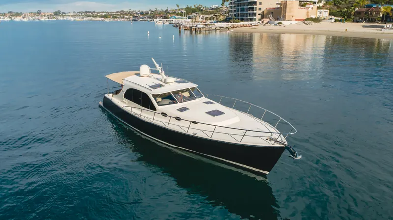 Slide: The Image of 2015 Palm Beach Motor Yachts 45 Sedan cruising on calm waters near a coastal city. - 28
