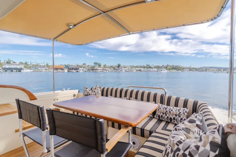 Slide: The Image of Outdoor seating on 2015 Palm Beach Motor Yachts 45 Sedan, overlooking serene waterfront. - 29