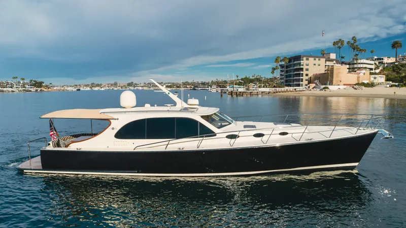 Slide: The Image of 2015 Palm Beach Motor Yachts 45 Sedan cruising on calm waters near a coastal city. - 3