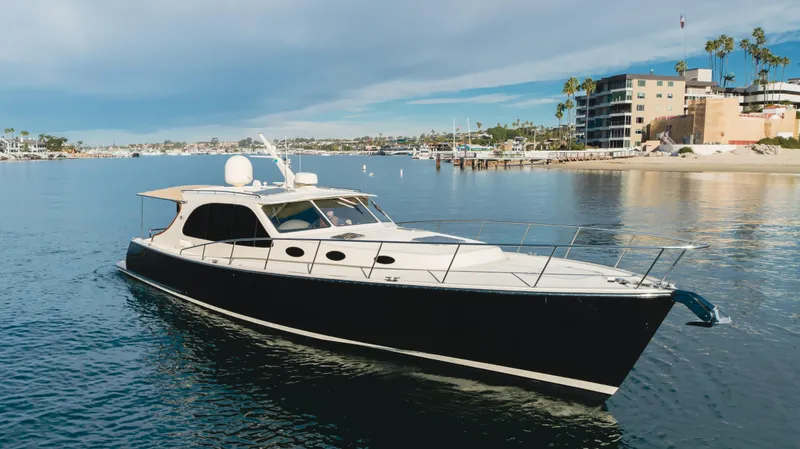 Slide: The Image of 2015 Palm Beach Motor Yachts 45 Sedan cruising in a scenic coastal area. - 32