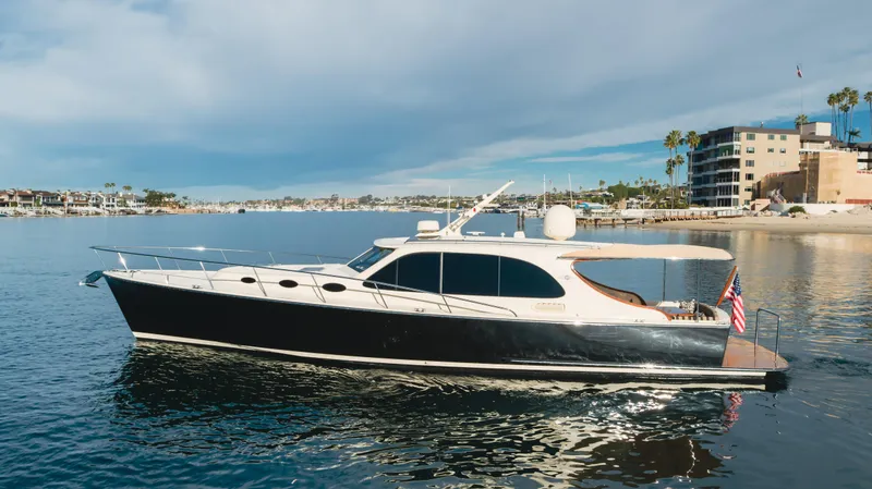 Slide: The Image of 2015 Palm Beach Motor Yachts 45 Sedan cruising on calm waters near a coastal city. - 36