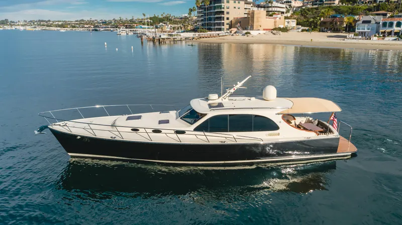Slide: The Image of 2015 Palm Beach Motor Yachts 45 Sedan cruising near a scenic coastline. - 38