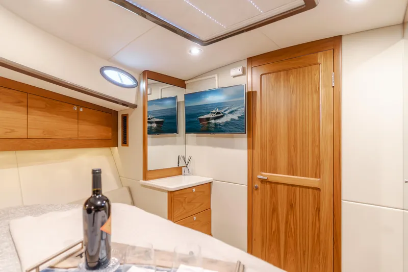 Slide: The Image of Interior of 2015 Palm Beach Motor Yachts 45 Sedan with wooden cabinetry and wine bottle. - 44