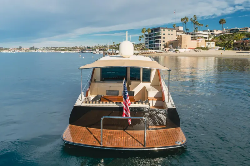 Slide: The Image of 2015 Palm Beach Motor Yachts 45 Sedan on calm waters near a coastal town. - 45