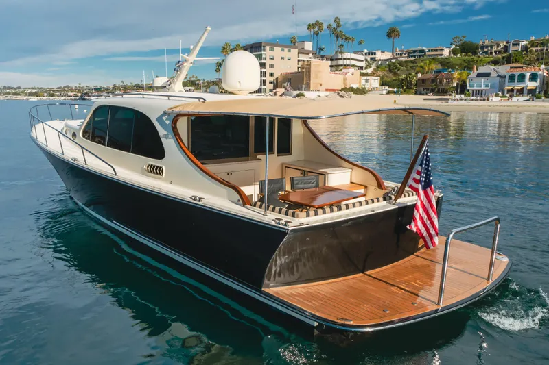 Slide: The Image of 2015 Palm Beach Motor Yachts 45 Sedan cruising near a scenic coastal area. - 5