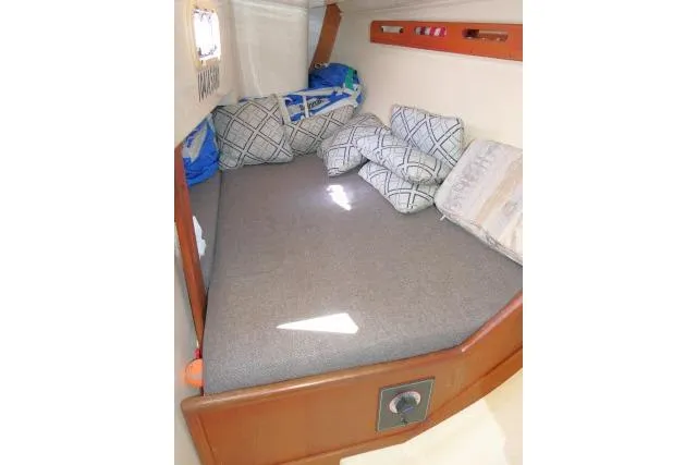 Slide: The Image of Cozy cabin interior of 1995 Tartan 3100 sailboat with cushions and bedding. - 17