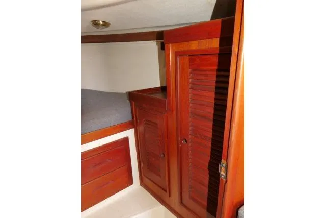 Slide: The Image of Interior of 1995 Tartan 3100 sailboat with wooden cabinets and cozy sleeping area. - 18