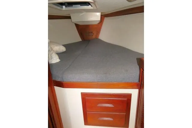 Slide: The Image of 1995 Tartan 3100 boat cabin with bed and wooden drawers. - 19