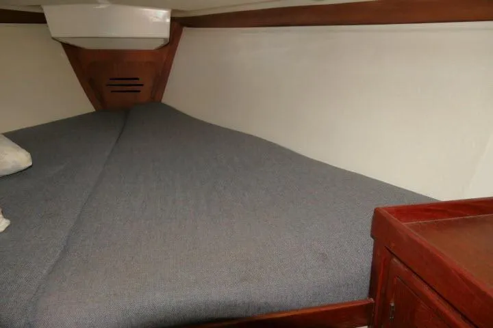 Slide: The Image of Cozy cabin interior of 1995 Tartan 3100 sailboat with wooden accents and cushioned berth. - 21
