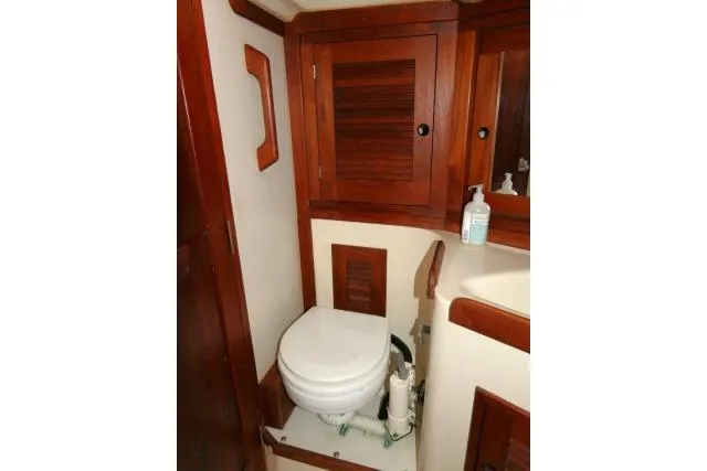 Slide: The Image of 1995 Tartan 3100 yacht bathroom with wooden cabinetry and marine toilet. - 22