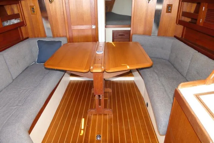 Slide: The Image of Interior of a 1995 Tartan 3100 sailboat with wooden table and cushioned seating. - 3