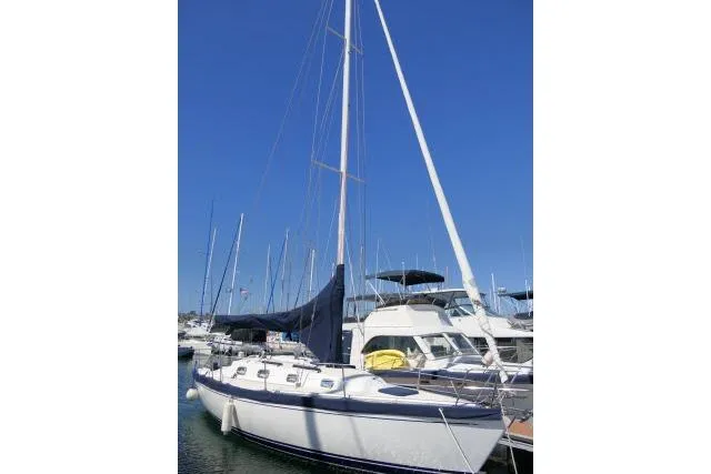 Slide: The Image of Sailboat Tartan 3100, 1995 model, docked in marina under clear blue sky. - 36