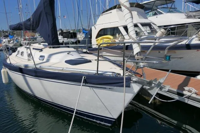 Slide: The Image of 1995 Tartan 3100 sailboat docked in marina, surrounded by other boats. - 38