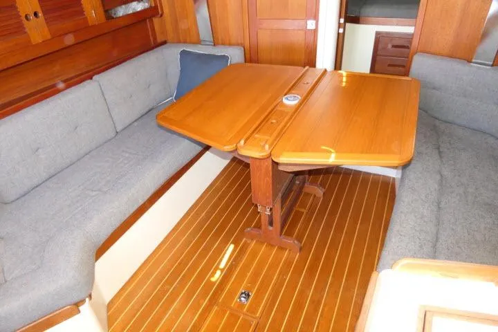 Slide: The Image of Interior of a 1995 Tartan 3100 sailboat with wooden table and gray seating. - 4