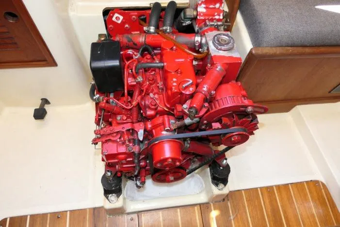 Slide: The Image of Red engine in a 1995 Tartan 3100 boat, mounted on a wooden floor. - 40