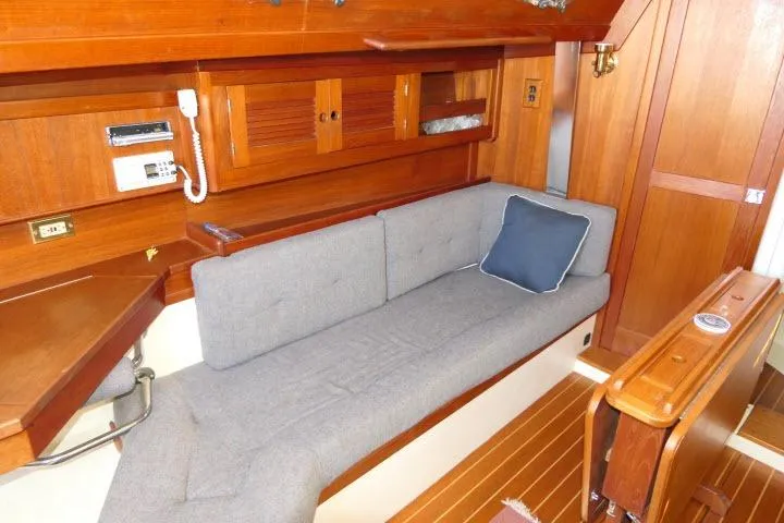 Slide: The Image of Cozy interior of 1995 Tartan 3100 sailboat with wooden finish and cushioned seating. - 6