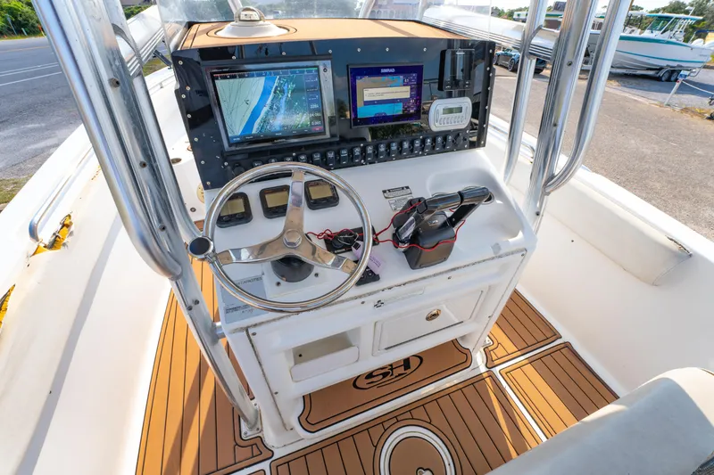 Slide: The Image of 2011 Sea Hunt Gamefish 25 boat console with navigation screens and steering wheel. - 10