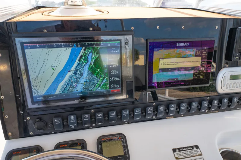 Slide: The Image of 2011 Sea Hunt Gamefish 25 dashboard with Garmin and Simrad navigation displays. - 11