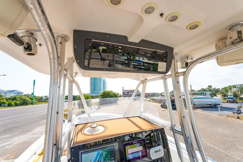 Slide: The Image of 2011 Sea Hunt Gamefish 25 boat console with navigation equipment and overhead storage. - 12