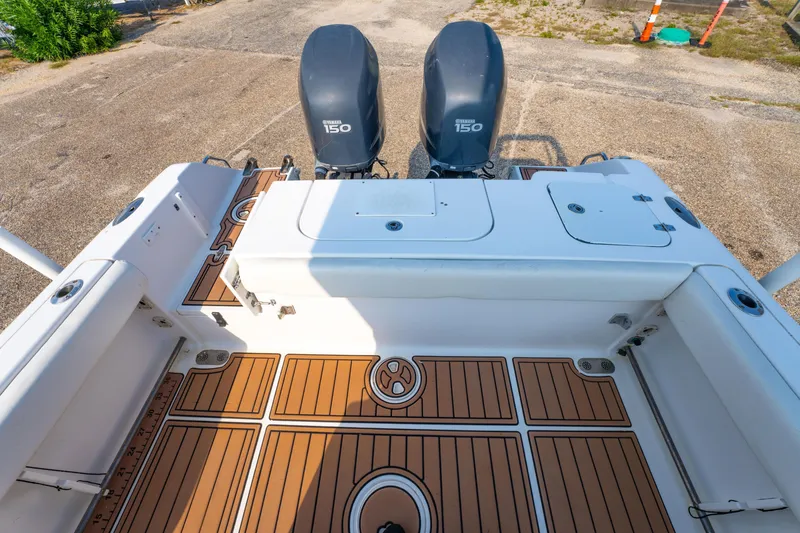 Slide: The Image of 2011 Sea Hunt Gamefish 25 boat deck with twin Yamaha 150 engines, featuring teak-style flooring. - 16