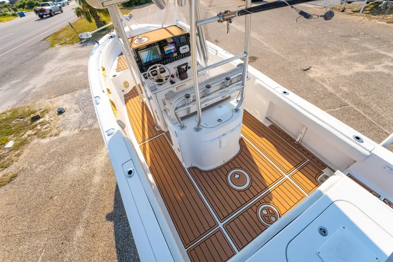 Slide: The Image of 2011 Sea Hunt Gamefish 25 boat interior with wood-style deck and modern controls. - 17