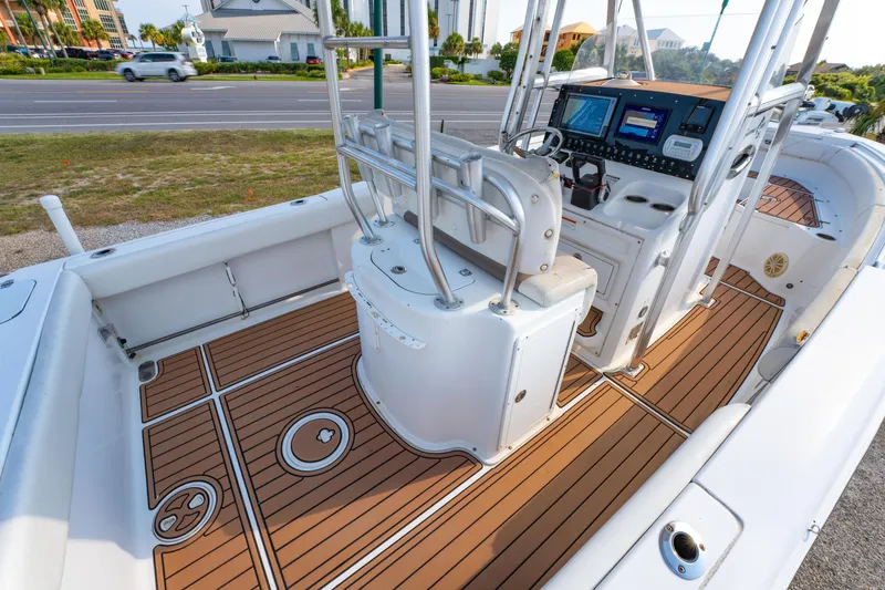 Slide: The Image of 2011 Sea Hunt Gamefish 25 boat interior with modern dashboard and teak flooring. - 18