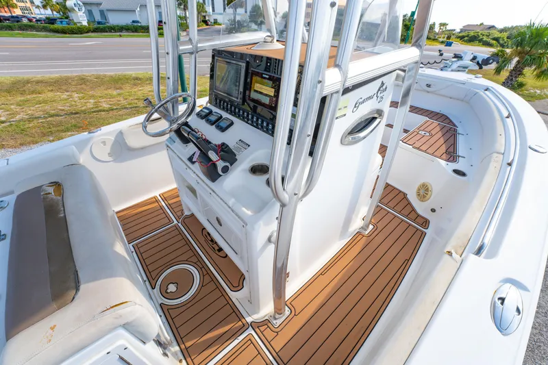Slide: The Image of 2011 Sea Hunt Gamefish 25 boat interior with steering console and teak flooring. - 19