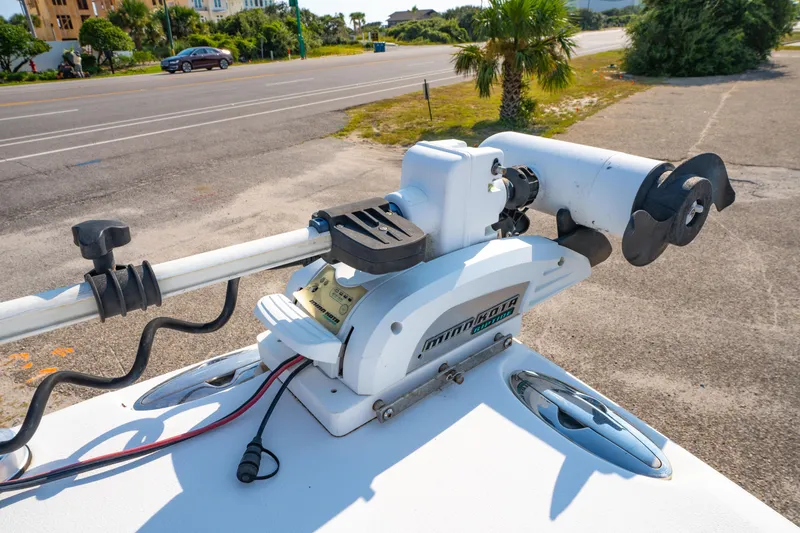 Slide: The Image of 2011 Sea Hunt Gamefish 25 with Minn Kota trolling motor on deck, near a road and palm tree. - 22