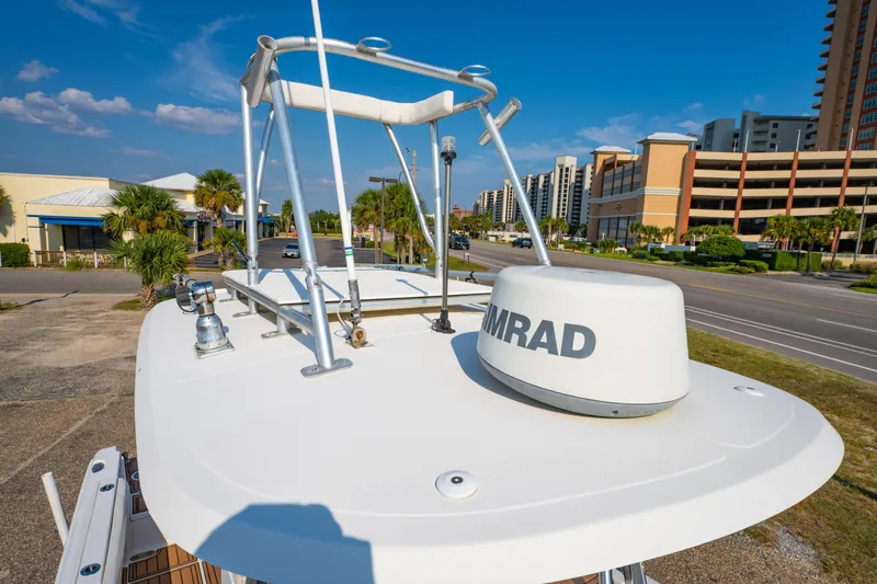 Slide: The Image of 2011 Sea Hunt Gamefish 25 boat with radar, parked near buildings and palm trees. - 23