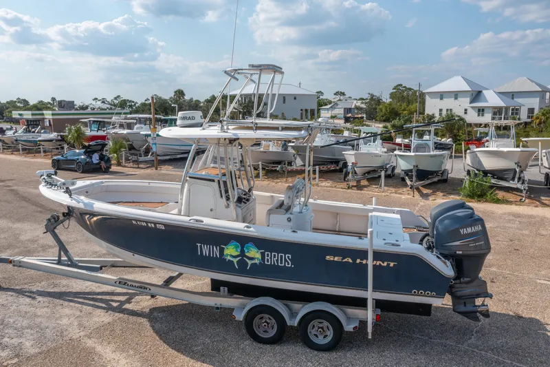 Slide: The Image of 2011 Sea Hunt Gamefish 25 boat on trailer, parked in marina with other boats. - 3