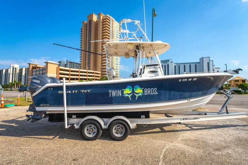 Slide: The Image of 2011 Sea Hunt Gamefish 25 boat on trailer, urban backdrop, clear sky. - 4