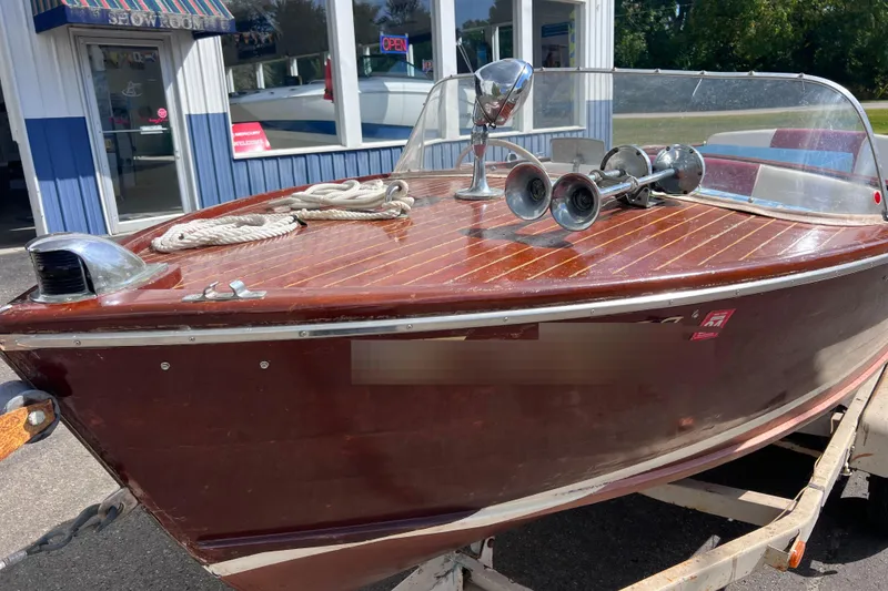 Slide: The Image of 1955 Chris-Craft 17 Cavalier wooden boat with chrome details on display. - 1