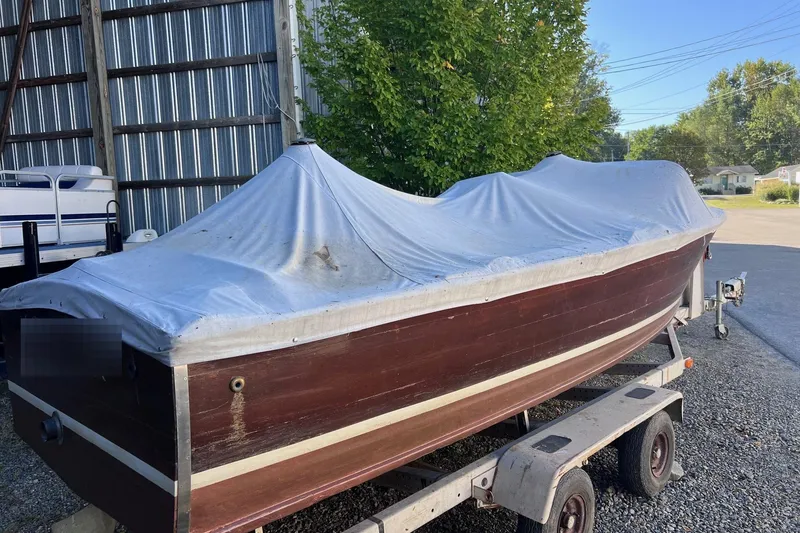Slide: The Image of 1955 Chris-Craft 17 Cavalier boat covered on a trailer, parked outdoors. - 16