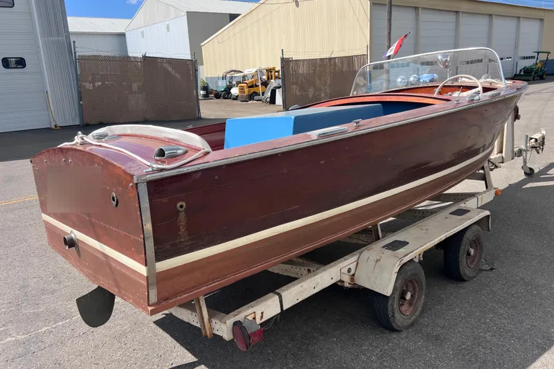 Slide: The Image of 1955 Chris-Craft 17 Cavalier wooden boat on trailer, parked outdoors. - 2