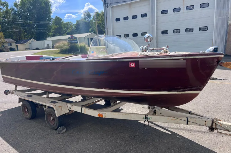 Slide: The Image of 1955 Chris-Craft 17 Cavalier boat on trailer, parked outside a garage. - 3