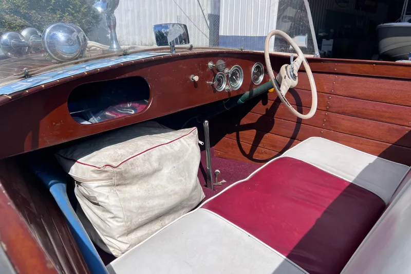 Slide: The Image of 1955 Chris-Craft 17 Cavalier interior with vintage steering wheel and wooden dashboard. - 6