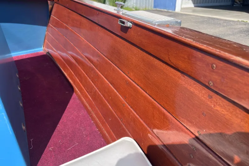 Slide: The Image of Interior of a 1955 Chris-Craft 17 Cavalier boat with polished wood and red carpet. - 9