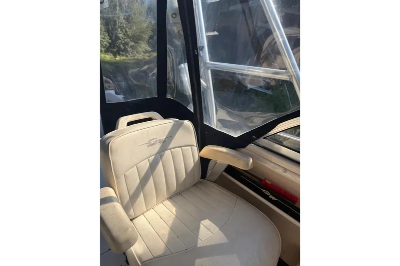 Slide: The Image of 2006 Grady-White Seafarer 228 boat with rod holders, surrounded by trees. - 17